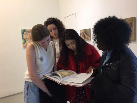 学者 peruse a catalogue at the Judy Chicago exhibit PowerPlay