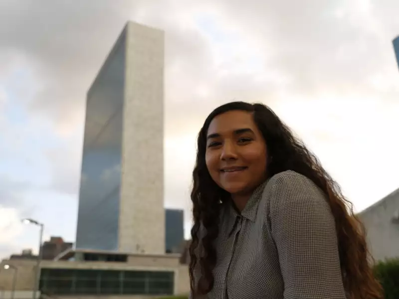 Young woman outdoors with a tall city building behind her