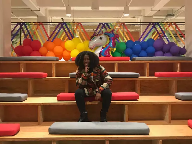 A Black woman sitting alone on some empty bleachers