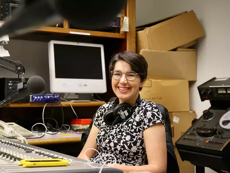 Young woman working at a radio studio board