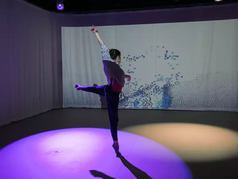 Female student dancing in a purple spotlight